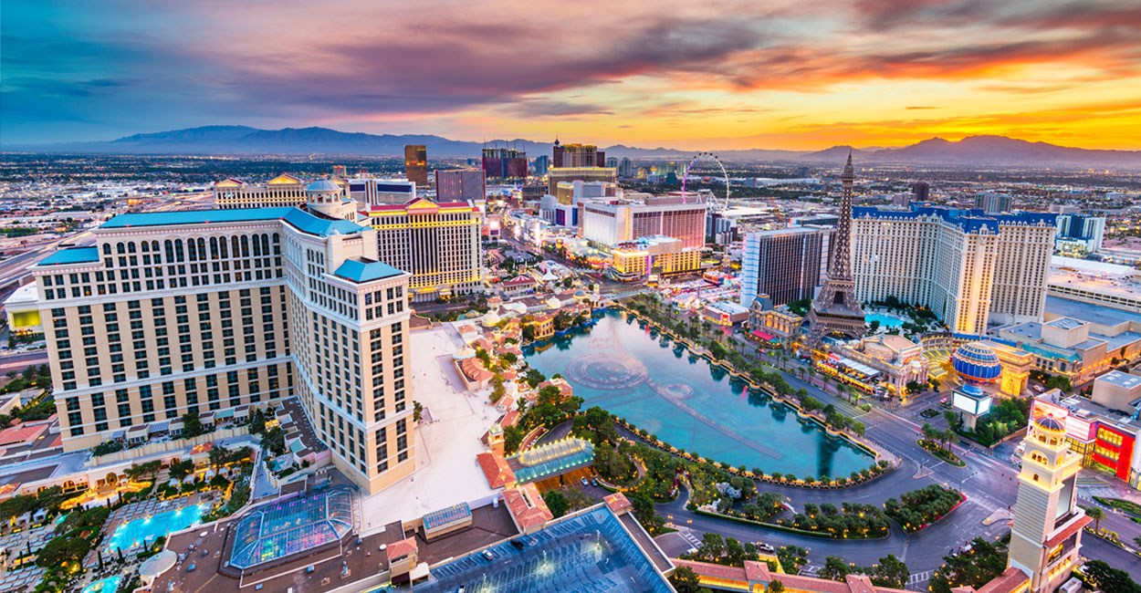 Night view of high-rise buildings and palm trees in Las Vegas.