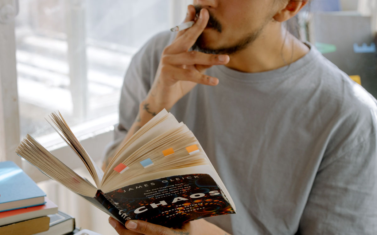 man in gray crew neck shirt smoking inside