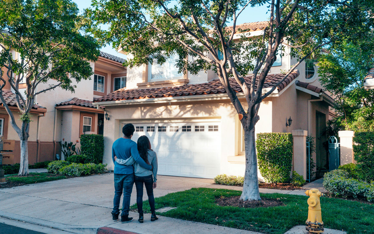 Couple Standing In Front of their New House