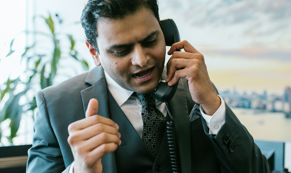 Man in Black Suit Talking on the Telephone