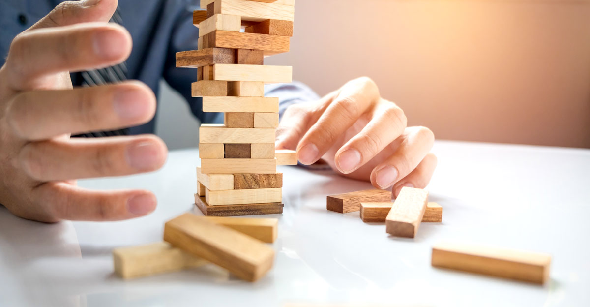 businessman gambling placing wooden block on a tower