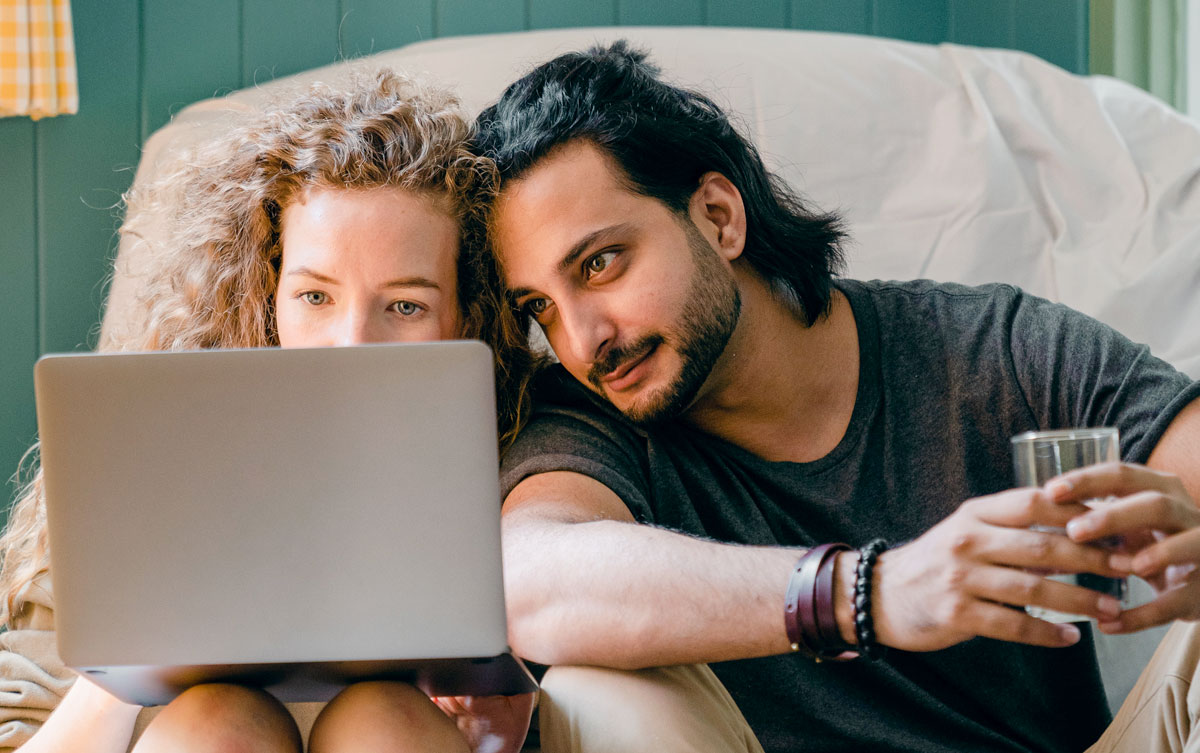 Youg couple browsing laptop on floor