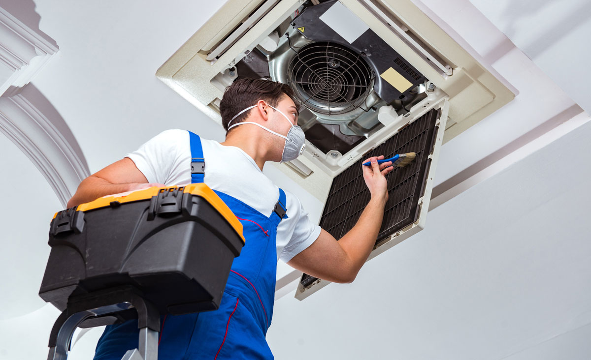 Worker repairing ceiling air conditioning unit