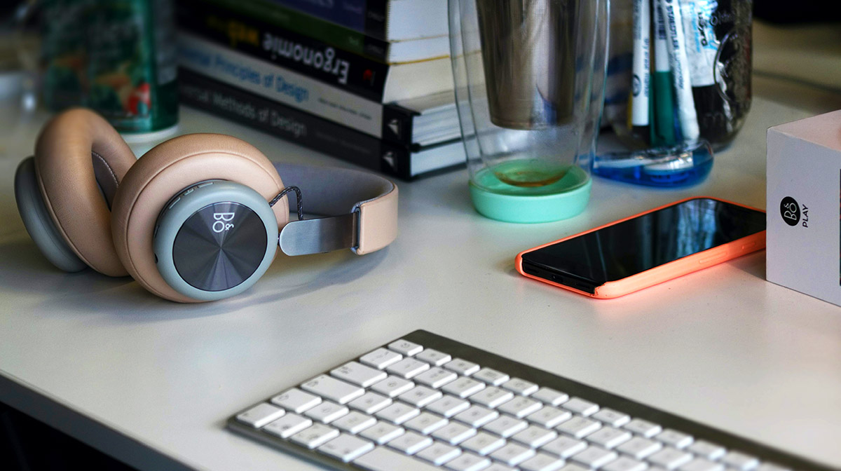 Wireless keyboard, headphones, and a phone.
