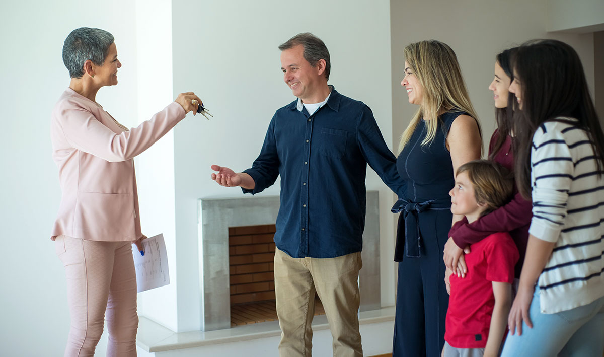 A woman giving house keys to a family