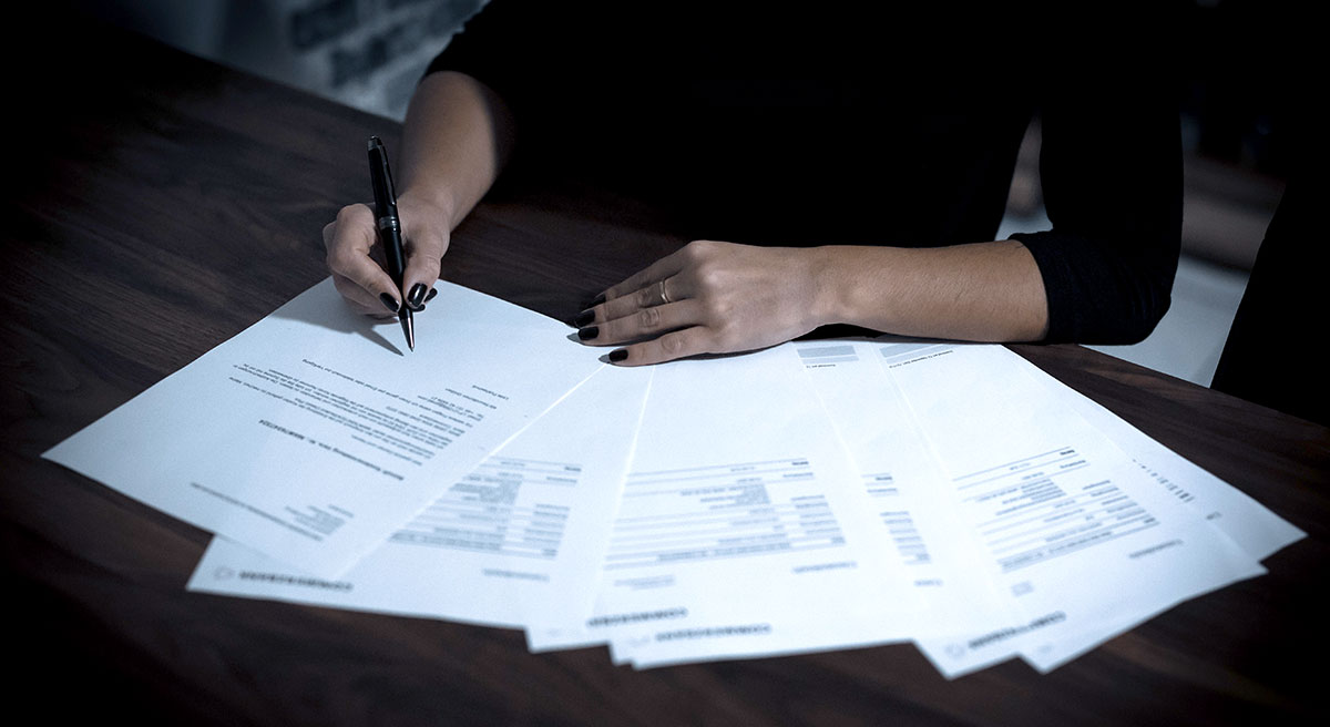 A person signing lease renewal paperwork.