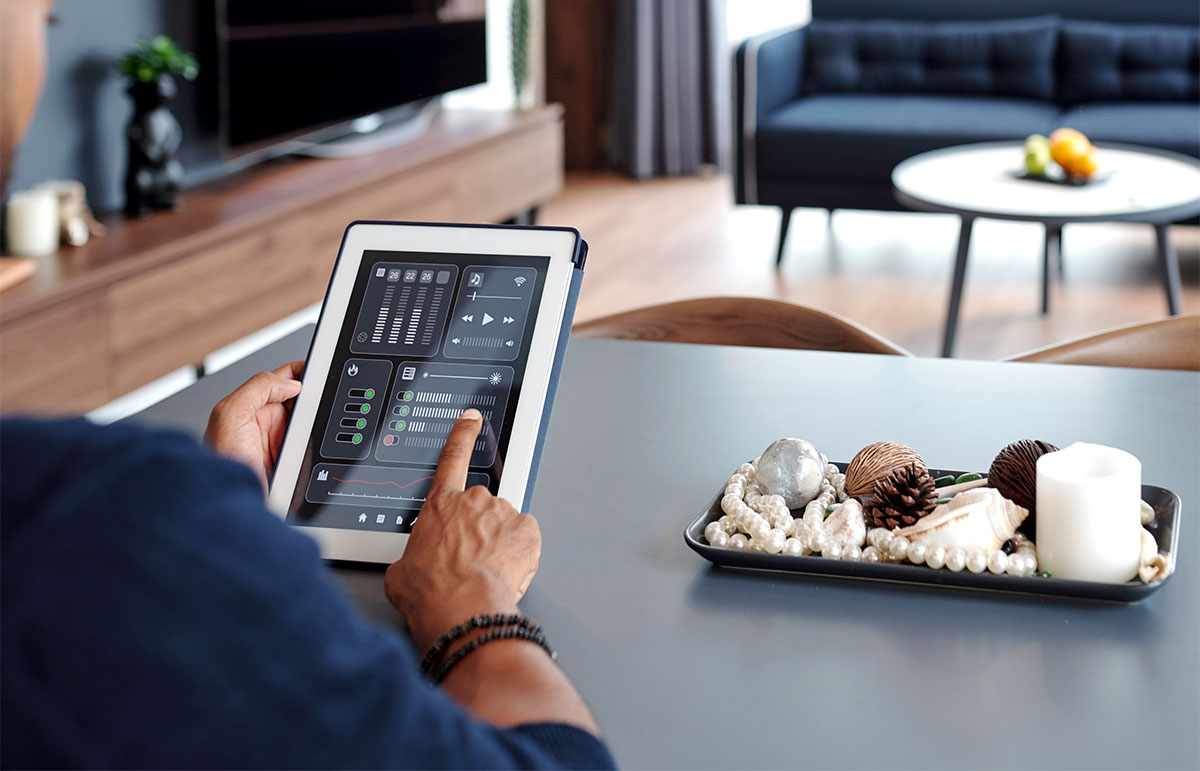 Man sitting at table and using smart home application on digital teblet