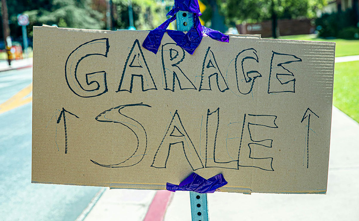 Garage sale sign written on a cardboard