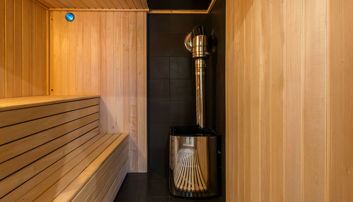 Modern sauna room with wooden benches and heater, one of the innovative features in Las Vegas apartments