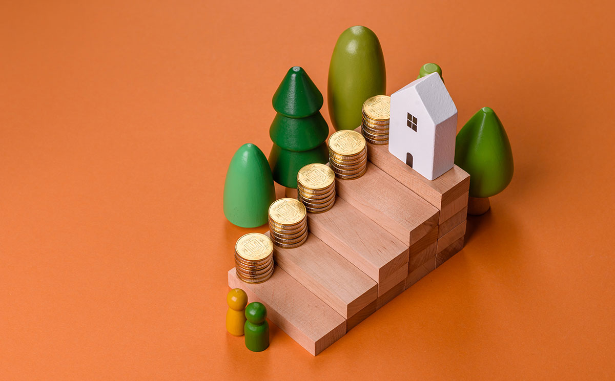Conceptual composition of wooden steps with coins model of a house