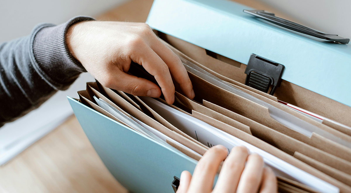 A person going through documents in a folder