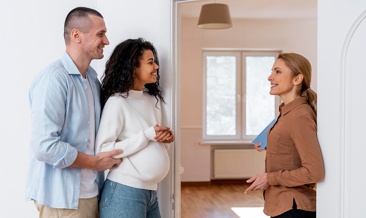 Side view of realtor inviting couple in to see new house