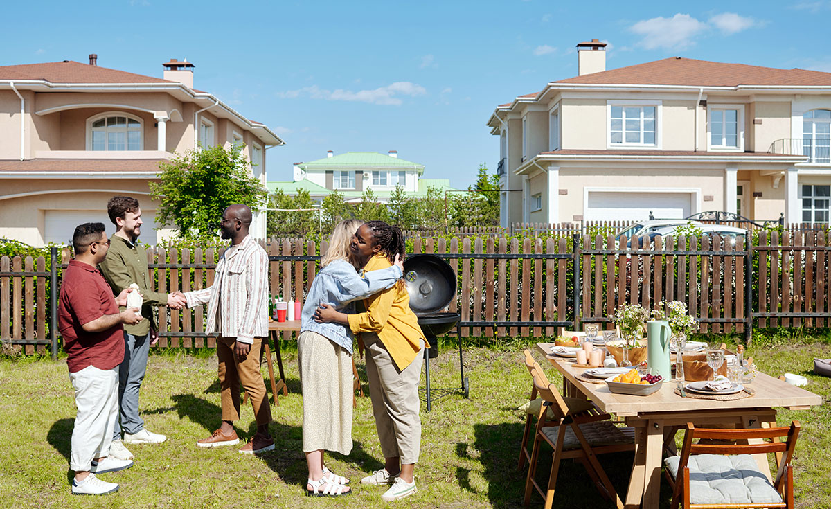 Happy young black man and woman meeting guests by served table