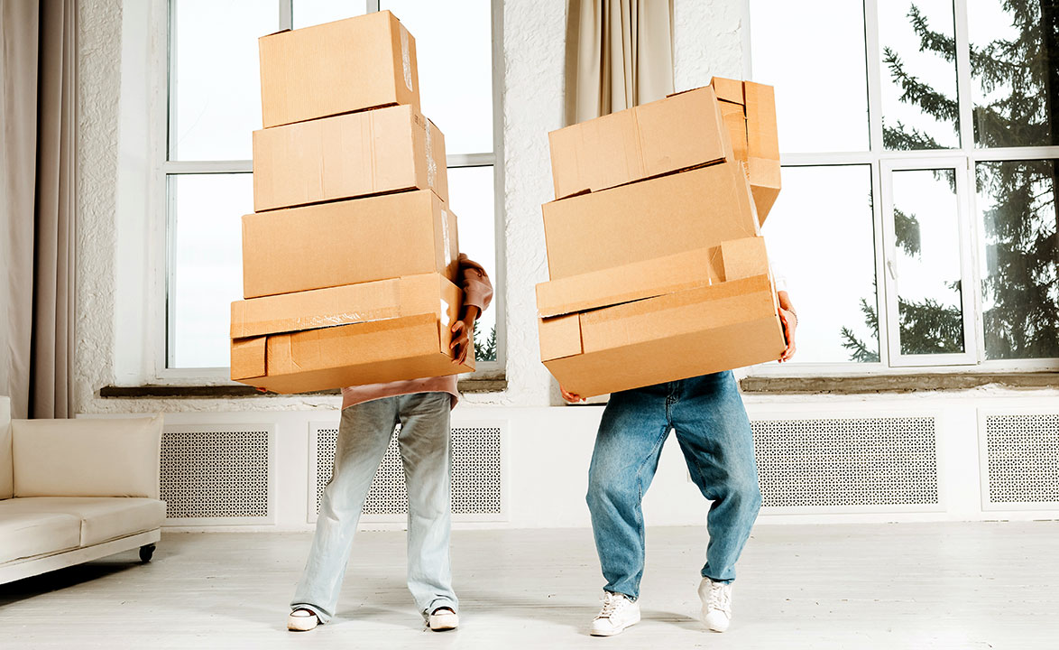 Young family couple man and woman moving with stack cardboard boxes to new buying real estate home apartment