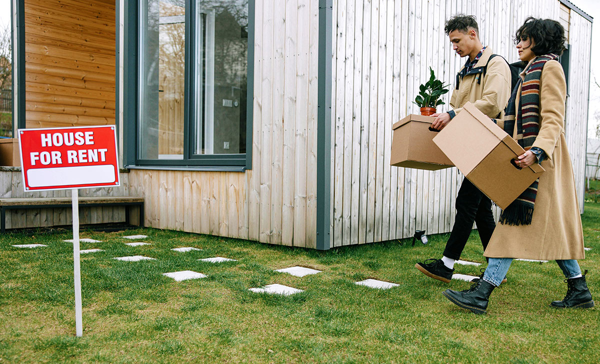 Two tenants carrying boxes into their home
