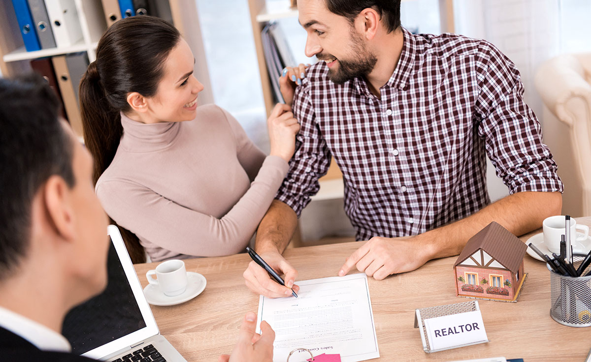 Joyful couple signs contract for purchase of new house
