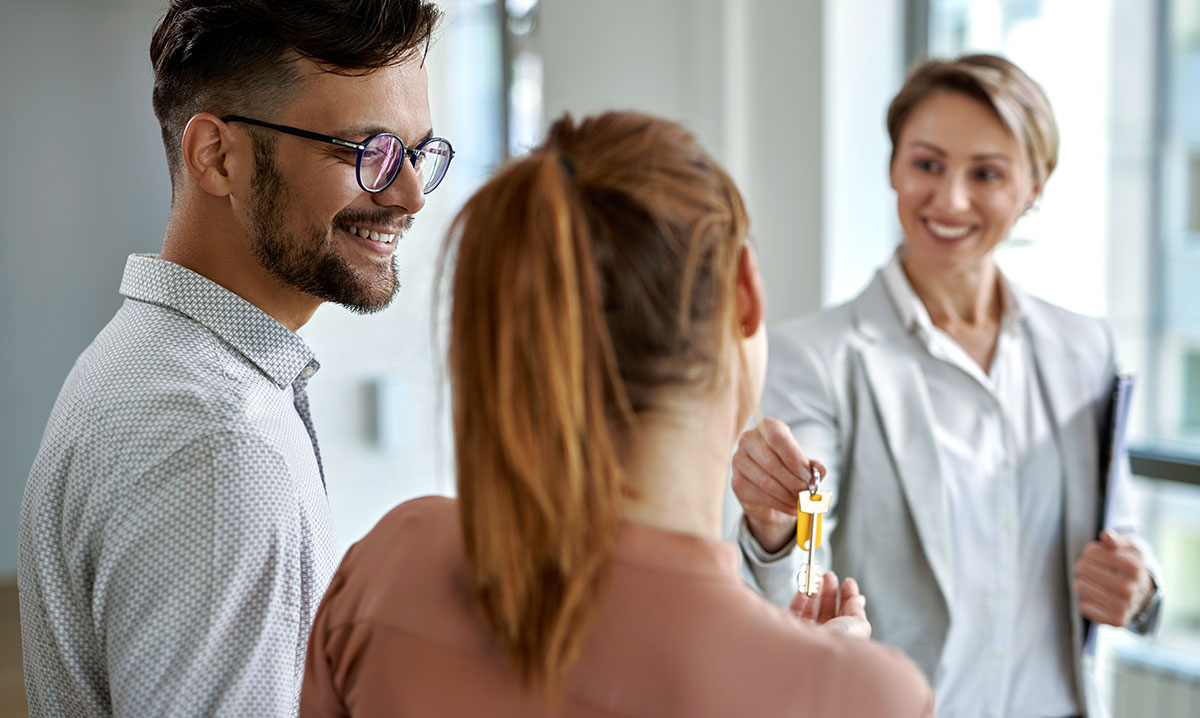 Smiling real estate agent talking with a couple interested in buying a new home