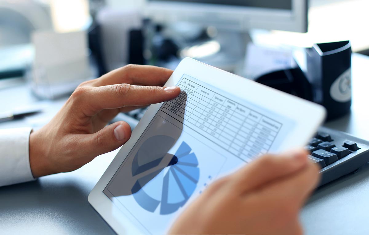 Business person analyzing financial statistics displayed on the tablet screen