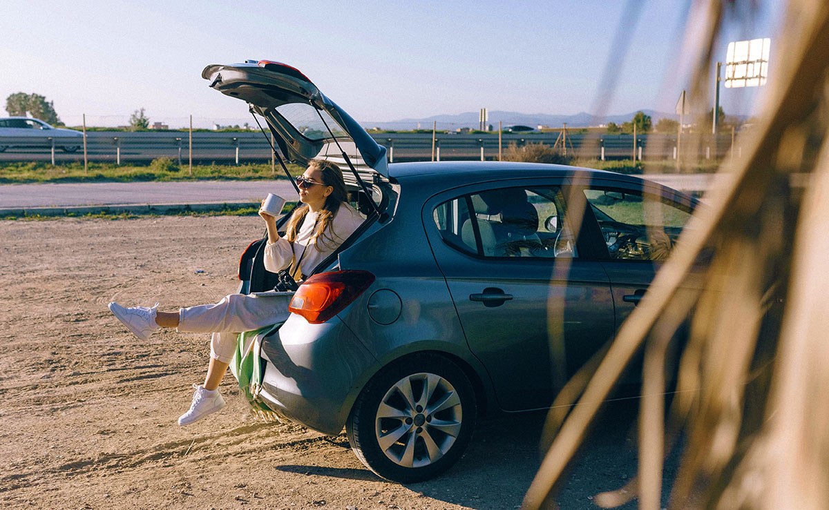 Woman sitting in a car trunk