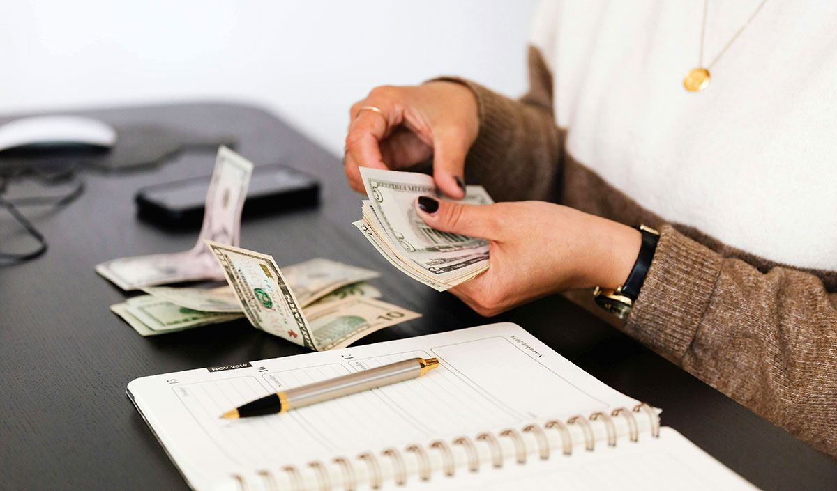 A woman counting bills with her hands