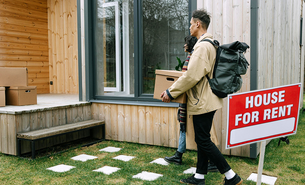A man carrying his things into a house