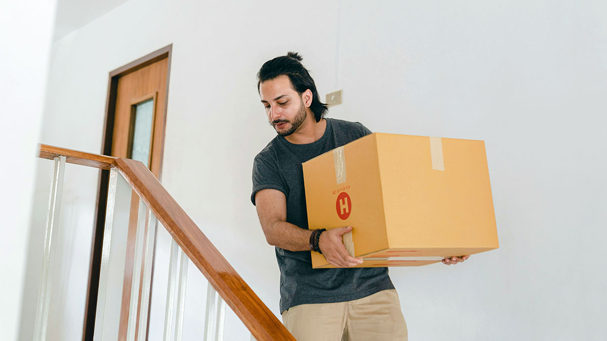 a young man carrying a box